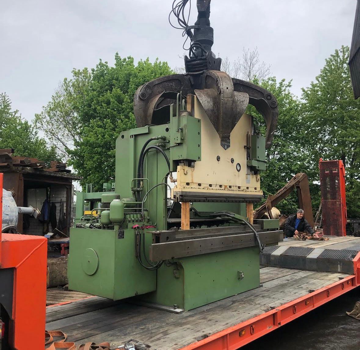 Maschine am Greifer auf Tieflader