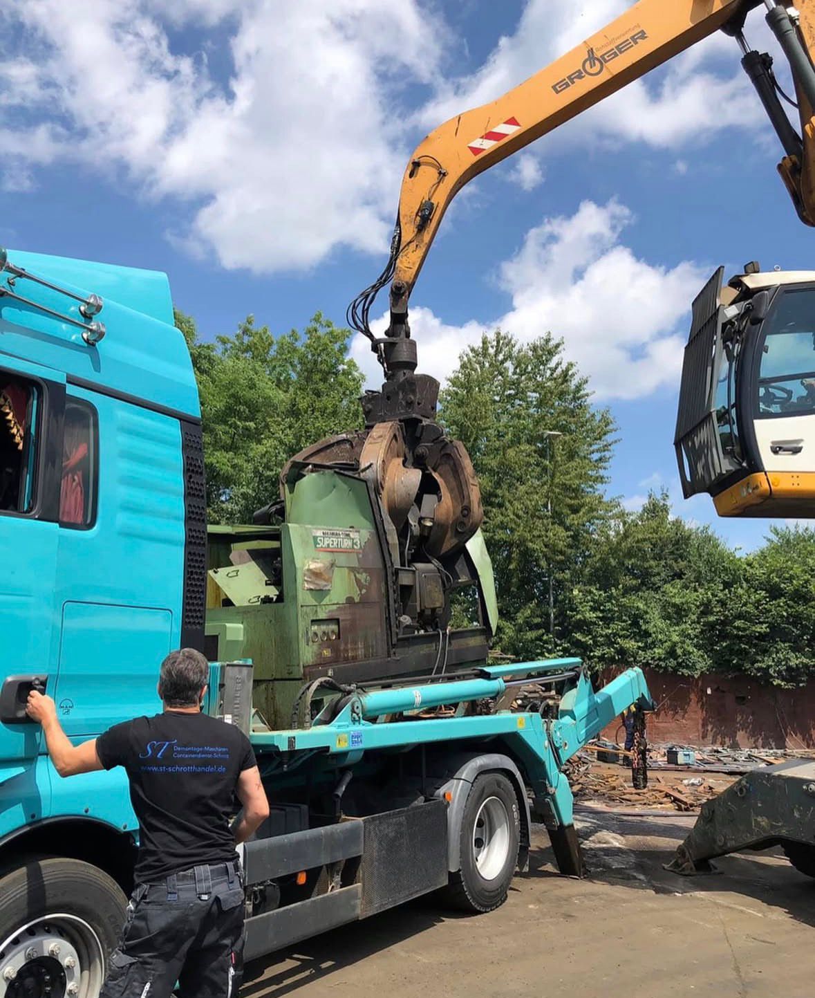 Bagger laedt Maschine auf LKW